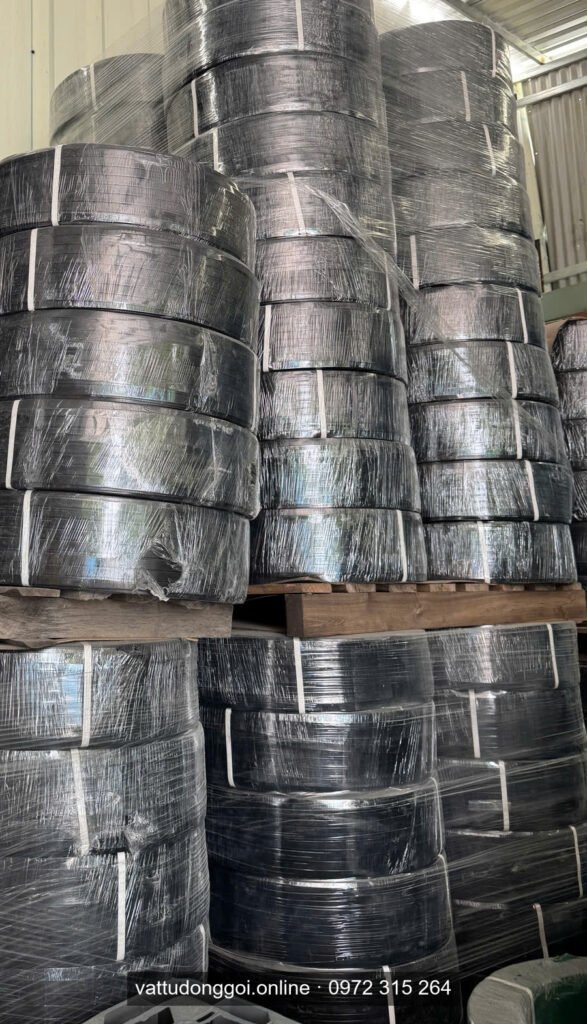 Chồng cuộn dây đai PET đen bọc màng co trên pallet gỗ