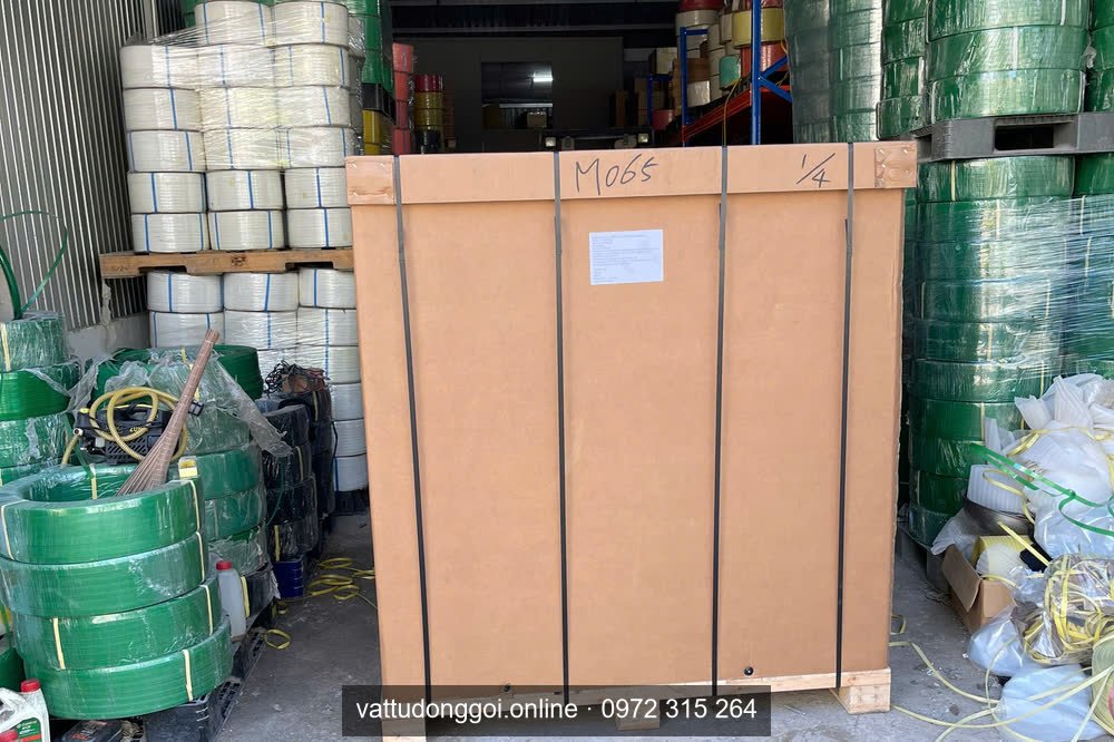 Bên trong container xếp cuộn dây đai xanh lá và trắng, có thùng gỗ đóng sẵn