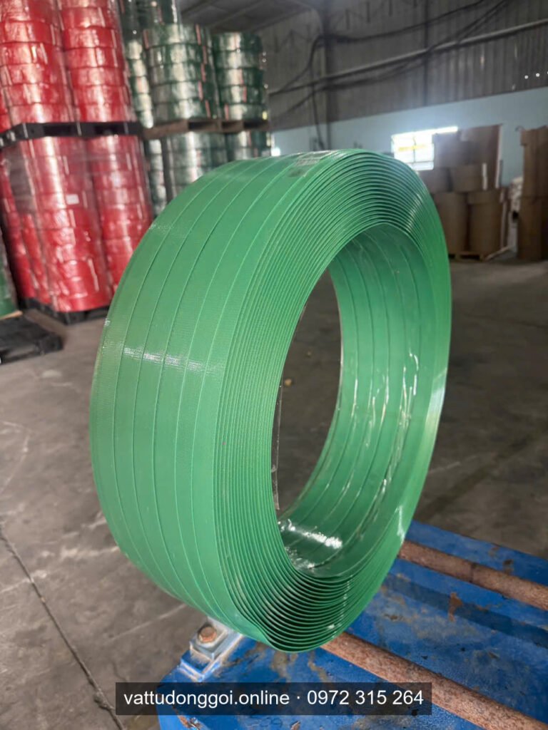 Cuộn dây đai PET xanh lá trong kho, phía sau là các cuộn dây đai màu đỏ