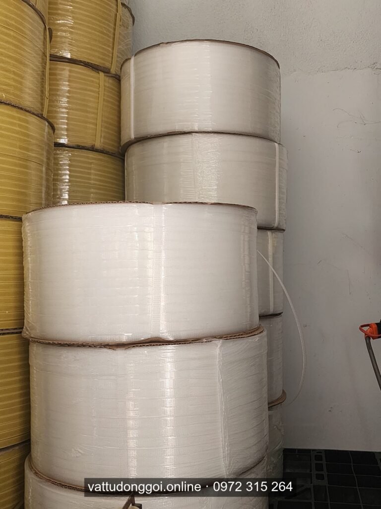 Cuộn dây đai PP màu trắng xếp chồng cạnh cuộn màu vàng