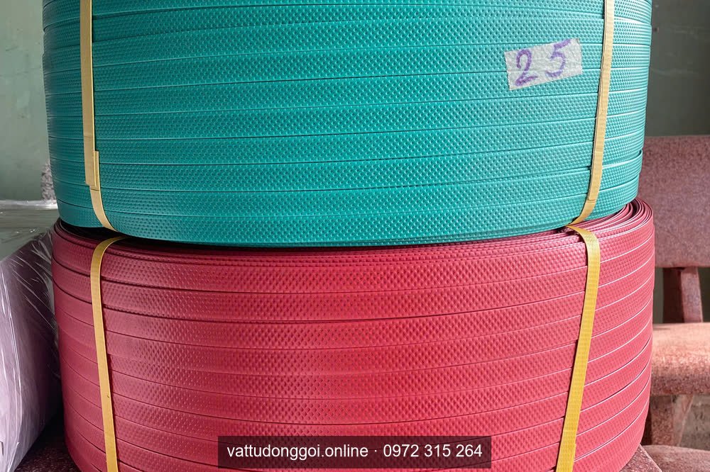 Cuộn dây đai PP màu xanh ngọc đặt cạnh cuộn màu đỏ để phân biệt PP và PET
