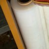 Cuộn màng PE trắng xếp cạnh nhau trên kệ, nhìn từ phía trái