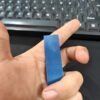Dây đai nhựa PET màu xanh dương cầm trên tay để so độ rộng bản dây