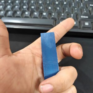 Dây đai nhựa PET màu xanh dương cầm trên tay để so độ rộng bản dây