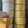 Cuộn dây đai PP màu trắng và vàng xếp chồng trong kho