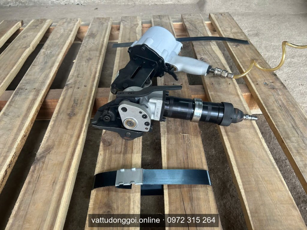 Bộ dụng cụ khí nén đóng đai thép trên pallet gỗ cùng đoạn đai đã khóa