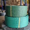 Hai cuộn dây đai nhựa PET màu xanh lá xếp chồng, có băng keo vàng giữ cuộn