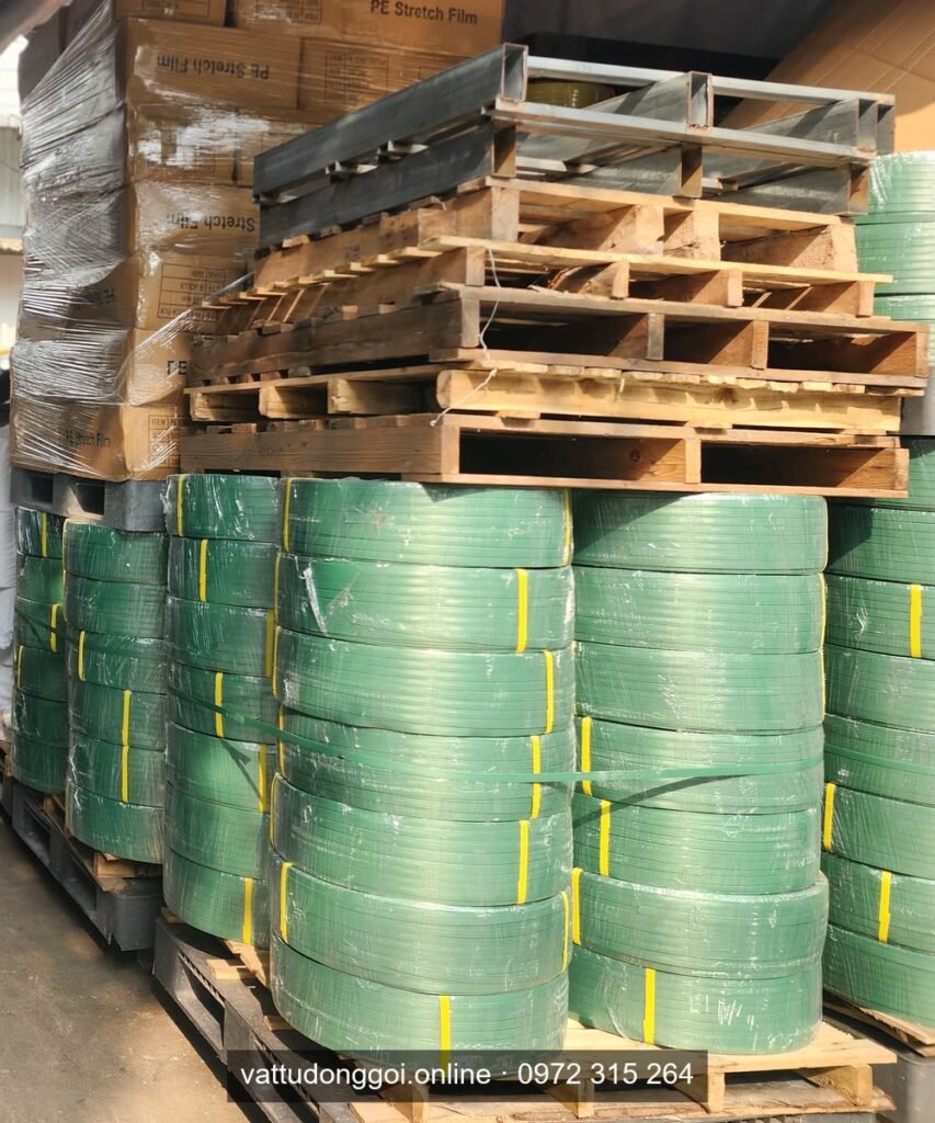 Pallet cuộn dây đai PET xanh xếp cạnh thùng màng PE quấn pallet chuẩn bị giao tận xưởng