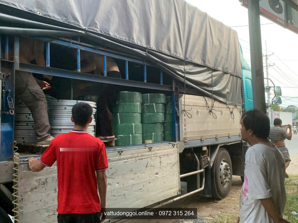 Xếp cuộn dây đai PET xanh và dây đai thép lên xe tải để đặt dây đai giao tận xưởng